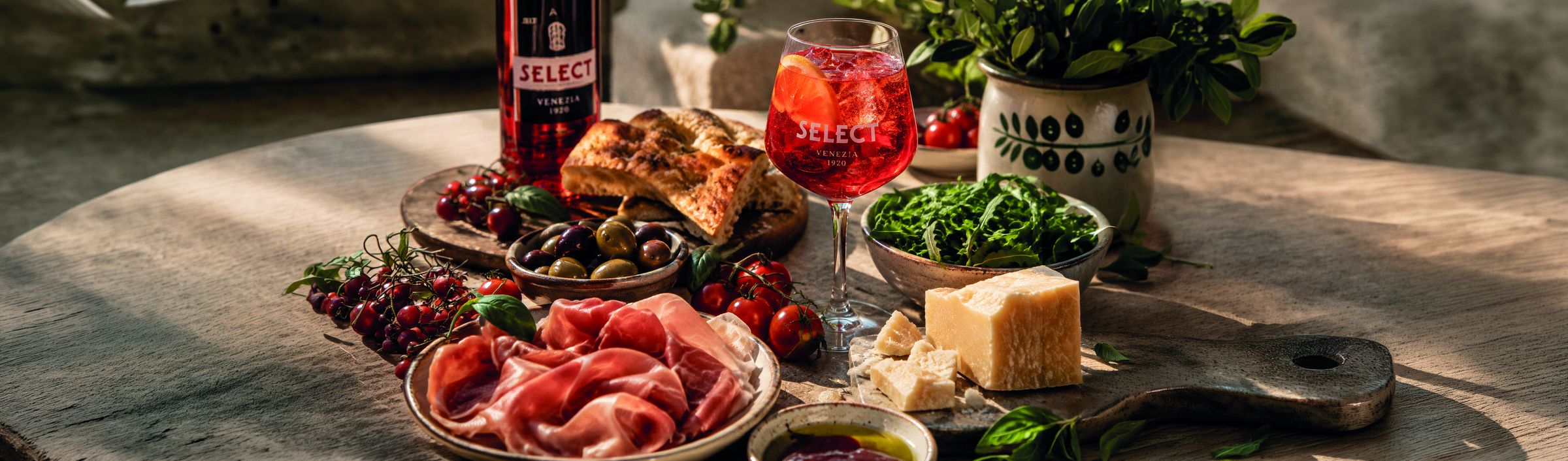 Aperitivo-Tisch mit Focaccia, Prosciutto, Parmigiano, Oliven und einem Spritz